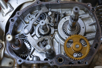 Detailed close up of an open motorcycle engine gearbox, showing complex metal gear mechanism and...