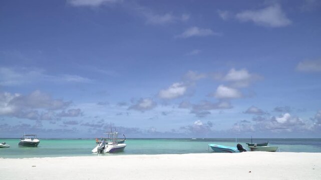 Maldives, clear blue sea, sandy beach, fishing and pleasure boats off the coast