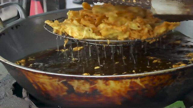 draining food that has been fried in hot oil in a frying pan 