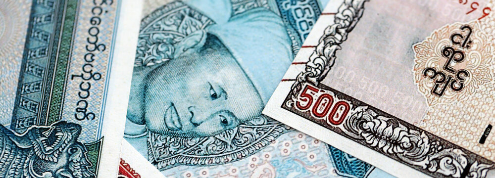 Myanmar kyat paper banknotes pile on table. Myanmar MMK currency money bills in big amount. Concept of economics, taxation and banking in Myanmar