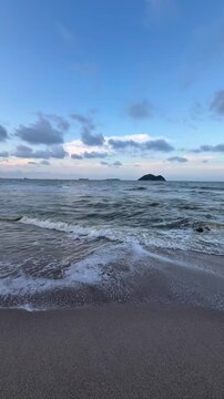 Cinematic view of ocean waves and scenic coastline at Samila Beach during sunset in Songkhla, Thailand.