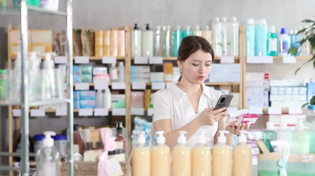 Young woman buyer scanning qr code for box of paracetamol tablets in pharmacy 