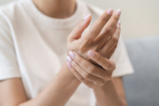 Health care and medical concept, rheumatism asian woman hand pain from cramp, trigger finger, wrist pain touching massaging, hand holding ache joint, arthritis inflammation.Chronic disease from injury