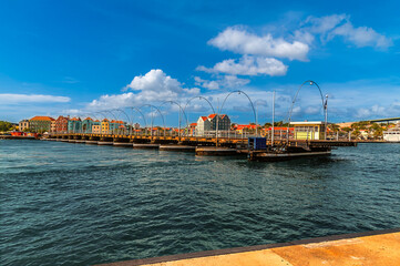 Naklejka premium A view of the floating Queen Emma Bridge opening in Willemstad, Curacao on a bright morning