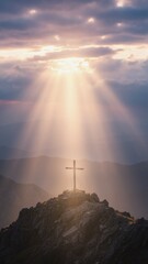 Naklejka premium Vertical view of wooden cross on mountain top illuminated by dramatic sun rays. Divine light beaming through clouds. Religious faith and hope concept