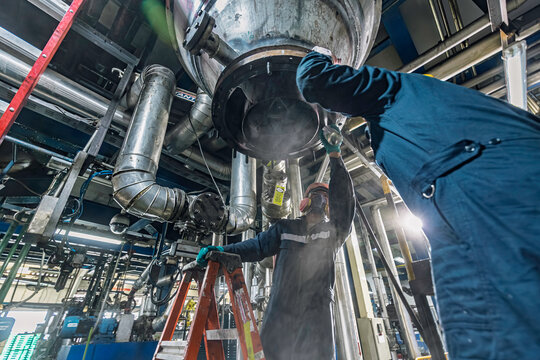 Male worker inspection weld tank, penetrant tank chemical grease