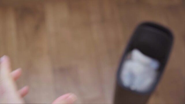 Close up of hands crushing plastic bottle and throwing it in trash concept of waste recycling and eco friendly habits