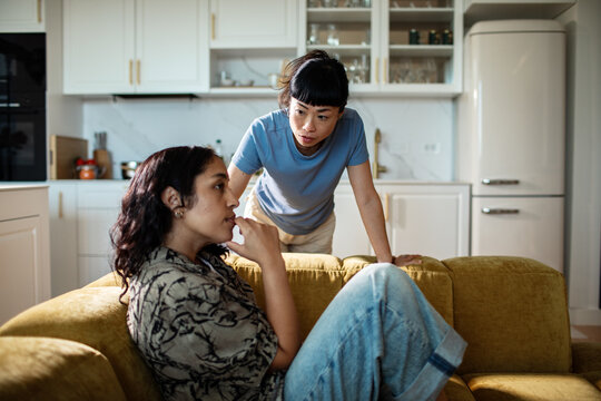 Two women having a serious conversation at home in the kitchen