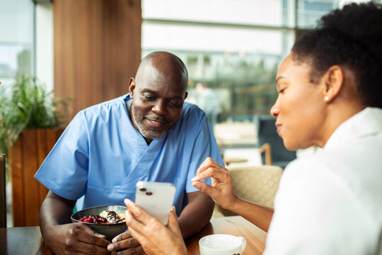 Medical colleagues looking at phone in hospital cafeteria