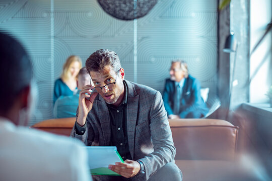 Businessman interviewing candidate in modern office lobby