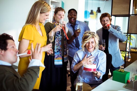 Coworkers celebrating a birthday in a modern office