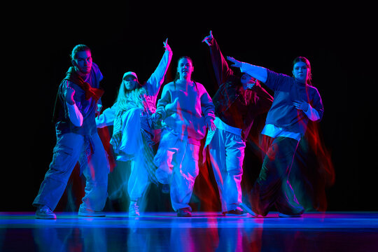 Hip hop dancers performing synchronized street dance with neon lighting and motion blur for music branding, nightlife promotion, entertainment advertising and youth culture campaigns