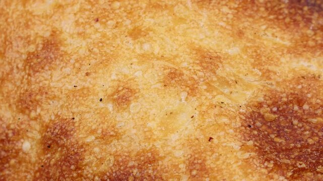 Crunchy fresh baked wheat bread crust texture circle rotation close up