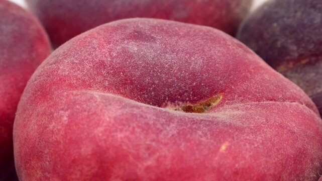 Fresh red flat peaches circle rotation close up