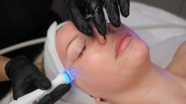 Cosmetologist performing a professional skin cleansing and rejuvenation procedure on a client's face