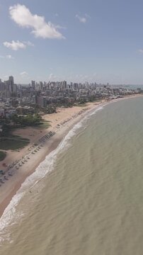 PRAIA DE CABO BRANCO, VISTA LINDA COM VARIOS PREDIOS E QUARDA SOL E UM MAR LINDO COM ONDAS (Cabo Branco Beach, beautiful view with various buildings and umbrellas and a beautiful sea with waves.)
