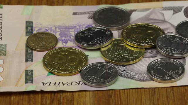 Ukrainian coins scattered on a 500 hryvnia banknote, symbolizing national currency and financial transactions.