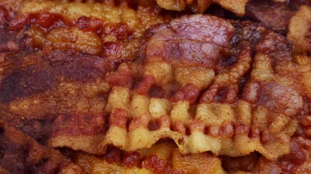 Slices of fried bacon circle rotation close up