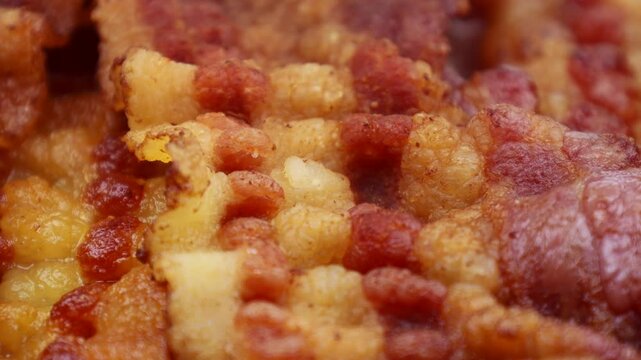 Slices of fried bacon circle rotation close up