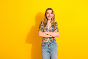 Young stylish woman model in floral top smiles against bright yellow background