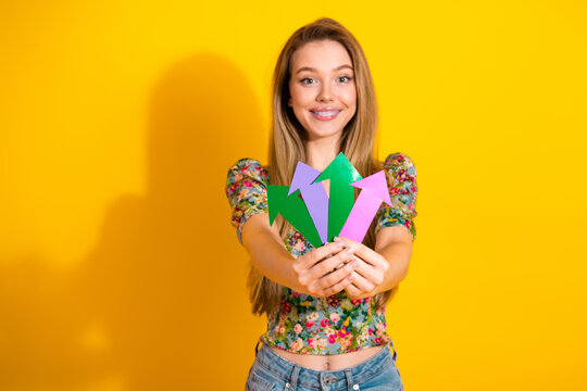 Young woman with colorful arrows stands against a yellow background for fashion lifestyle and advertising