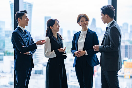 オフィスで会話する日本人ビジネスチームのミーティング風景