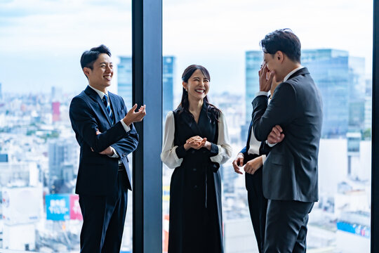 オフィスで会話する日本人ビジネスチーム