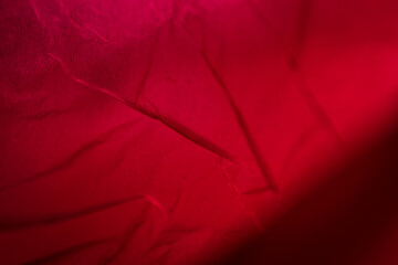 Extreme close up of red empty plastic bag background. The plastic surface is wrinkly and tattered...
