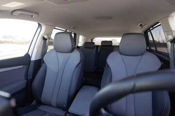 Interior of new modern clean expensive car. Passenger seats with leather. Closeup details. New electric car inside. Car cleaning theme. Luxury car rear leather seats row © uflypro