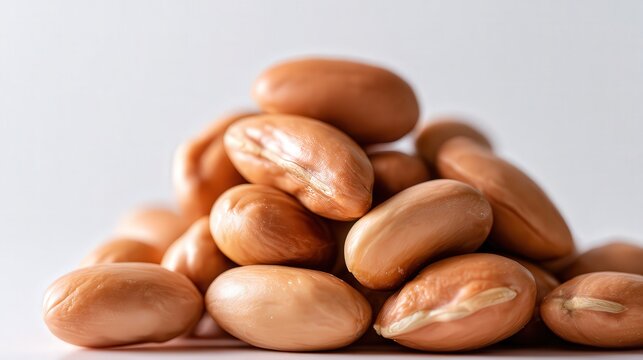 A close-up of a pile of raw, oval-shaped beans with a smooth texture, ideal for illustrating nutrition, cooking, or healthy eating concepts in publications or online content,
