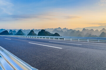 Empty asphalt highway and scenic karst mountain landscape at sunset in Guilin, Guangxi, China. © ABCDstock