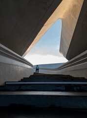 Fototapeta premium Person walking up in the stairs towards open bright space. The way forward. Personal targets achievement