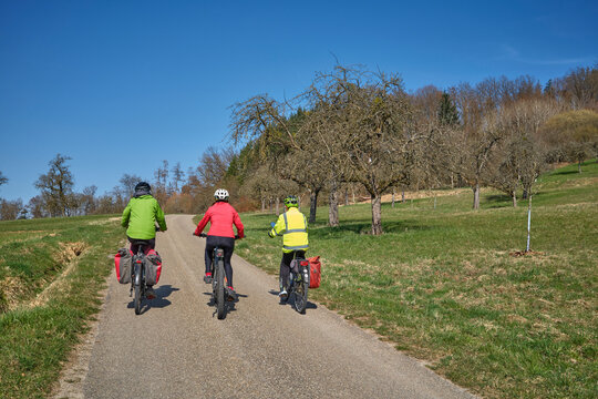 Group of active senior women enjoying a bicycle tour on a sunny spring day in the Swabian Forest, Germany. Friends cycling together through nature, promoting healthy lifestyle, recreation, and outdoor