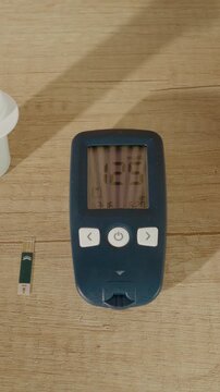 Vertical Screen: A glucometer shows a high reading of 125 mg dL on a wooden table. Monitoring blood sugar is important for diabetes management. Take action if results are concerning.