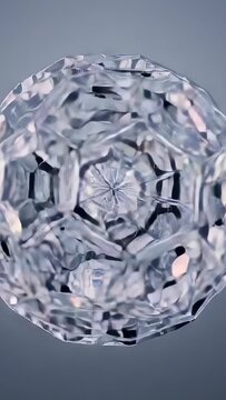 Vertical video: Rotating faceted orb revealing core pattern with camera shifting on grey backdrop
