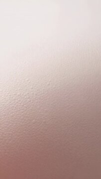 Vertical video: Recording camera keeping steady close-up on interior wall, showing stippled texture