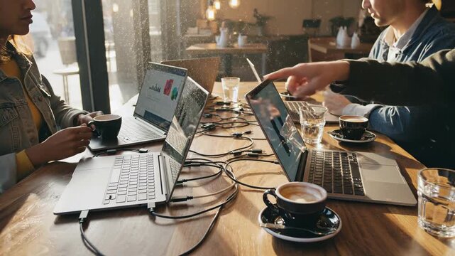 Coffee laptops and technology for remote work digital nomads lifestyle with young professionals collaborating on projects in a cozy cafe setting Connectivity networking and communication with
