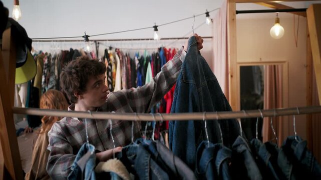 Youth Shopping Jackets. Teenage Individual Evaluates Traditional Denim Outerwear Choices Carefully