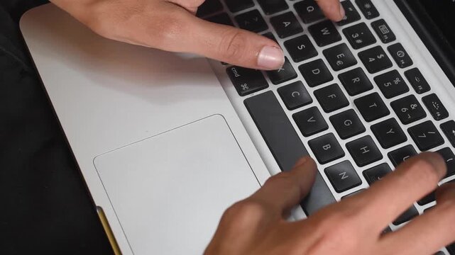 Toma cerrada de una persona trabajando en su laptop con sus manos