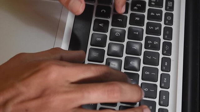 Toma cenital de una persona tecleando en su laptop