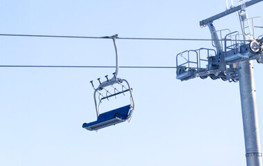 Empty ski lift chair lift isolated against bright blue sky.