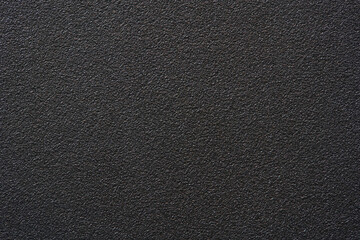 Fototapeta premium Black textured plastic surface background full frame top view of rough matte electronics casing material, dark abstract backdrop wallpaper technology design template, high resolution detail, no people