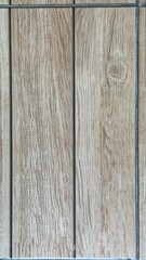 Obraz premium Straight-on capture of a light brown ceramic floor tile designed with vertical faux wood grain and a visible knot.