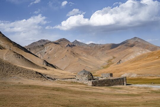 Historic caravanserai Tash Rabat from the 15th century, with yellow hills, Atbashy district in the Naryn region, Kyrgyzstan