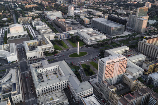 Aerial view of the EUR district's rationalist architecture and the obelisk in the center, bathed in the soft light of dusk, Rome, Lazio, Italy.