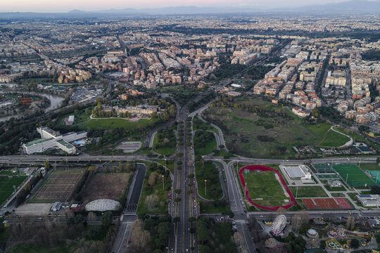 Aerial view of the vibrant green spaces meeting the urban fabric near Stadio delle Terme di Caracalla, a mosaic of life under the soft Italian sky, Rome, Lazio, Italy.