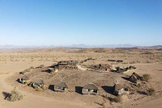 The Doro Nawas Camp and arid desert plains at the edge of the dry river bed of the Aba-Huab river, aerial view, drone shot, Damaraland, Kunene Region, Namibia