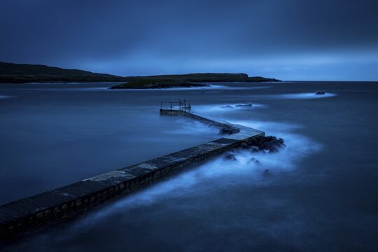 Sea surf on concrete jetty at blue hour, Beara Peninsula, Ireland