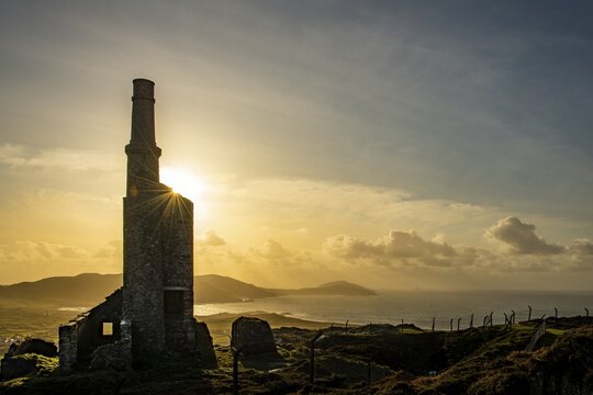 Old industrial plant backlit at golden hour, Beara Peninsula, Ireland