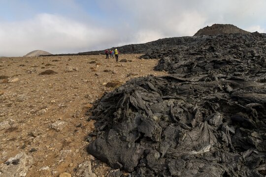 Tourists walk along cooled lava flows, extinct crater, Fagradalsfjall table volcano, Kr&yacute;suv&iacute;k volcanic system, Reykjanes Peninsula, Iceland